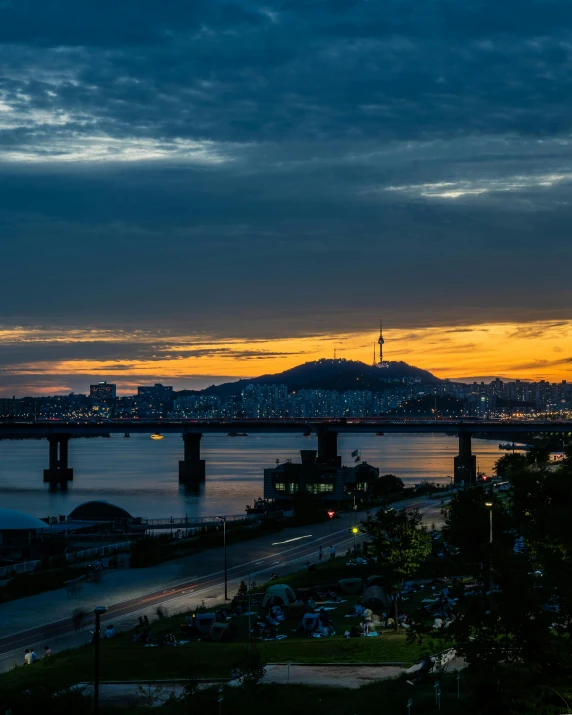 a view of a bridge over a body of water, by Jang Seung-eop, pexels contest winner, happening, vista of a city at sunset, seoul, slide show, hills in the background