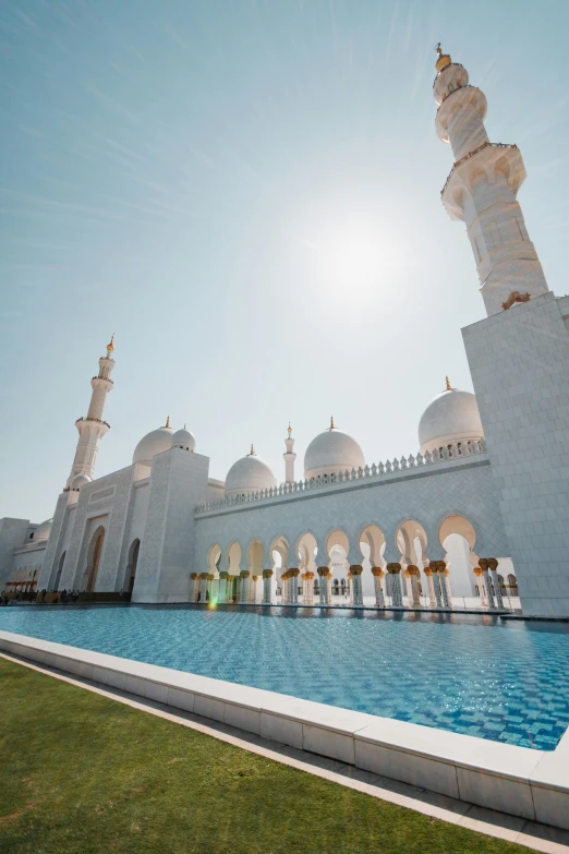 a large white building with a pool in front of it, inspired by Sheikh Hamdullah, unsplash contest winner, arabesque, domes, walt disney world, lawn, sun drenched