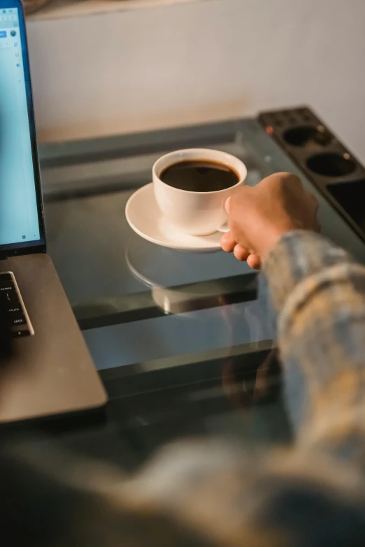 a person holding a cup of coffee in front of a laptop, 6 : 3 0 am, curated collections, digital image, opening shot