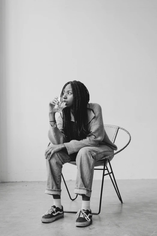 a black and white photo of a man sitting on a chair, inspired by Sarah Lucas, pexels contest winner, african american young woman, young woman with long dark hair, promotional image, juice