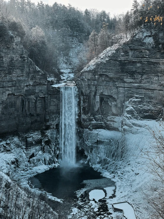 a waterfall in the middle of a snowy forest, an album cover, pexels contest winner, hudson river school, ellora, 2022 photograph, landscape photo