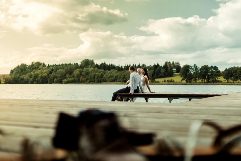 a man and a woman sitting on a dock next to a lake, by Jesper Knudsen, pexels contest winner, romanticism, movie still 8 k, wonderful details, colour photo, bottom shot