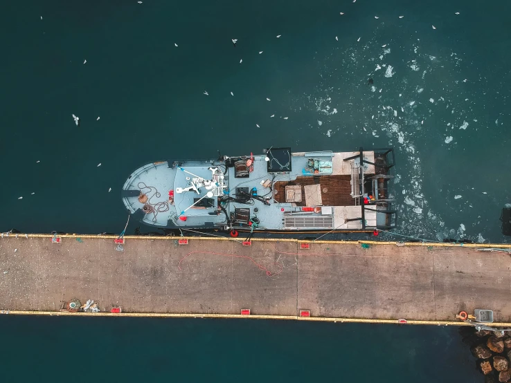 a boat that is sitting in the water, by Adam Marczyński, pexels contest winner, hurufiyya, utilitarian cargo ship, bird view, automated defence platform, casually dressed