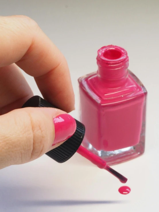 a person holding a pink nail polish bottle, a photorealistic painting, by Doug Ohlson, pexels contest winner, square, instructions, enamel, performing