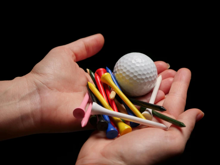 a person holding a bunch of golf tees and a golf ball, inspired by Lorenzo Lotto, unsplash, 15081959 21121991 01012000 4k, multi - coloured, miscellaneous objects, nerves