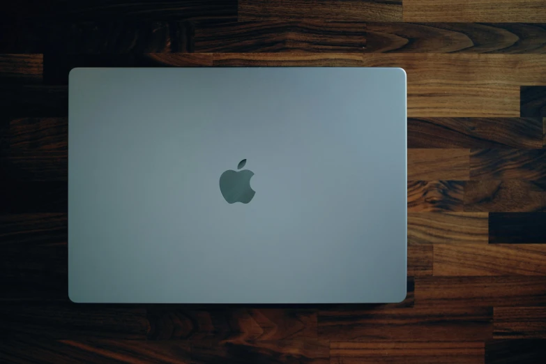 an apple laptop sitting on top of a wooden floor, by Carey Morris, pexels, rear-shot, ignant, rectangle, 12k