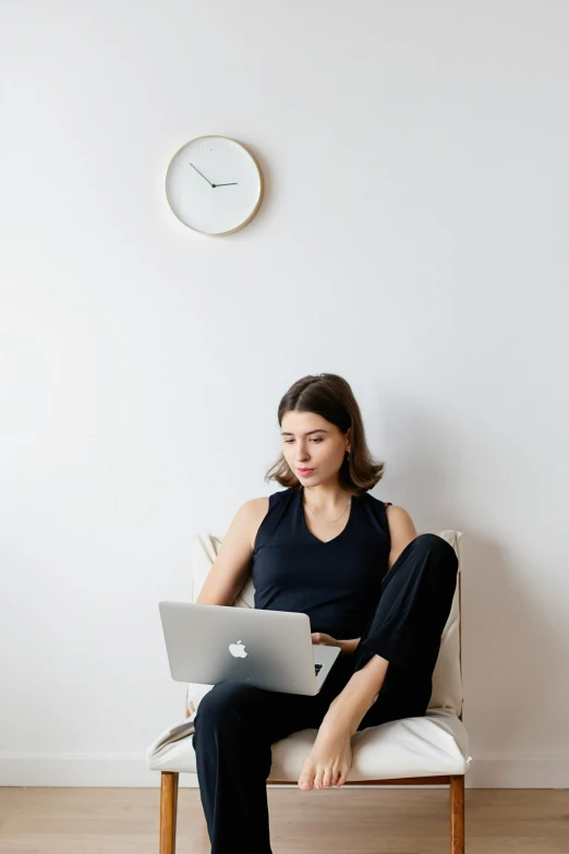 a woman sitting on a chair with a laptop, by Carey Morris, trending on unsplash, white background, office clothes, wearing a muscle tee shirt, sleepy