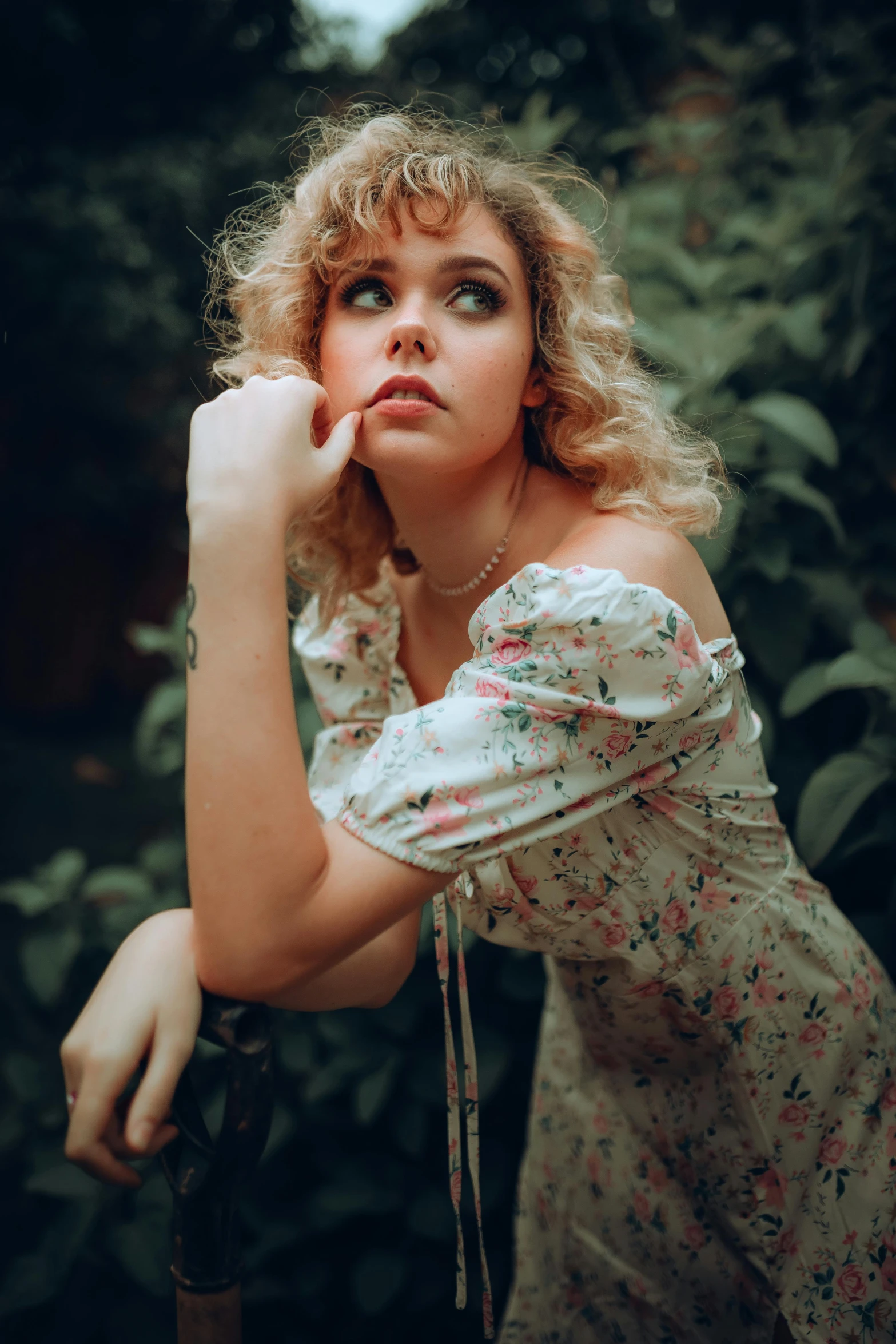 a woman in a floral dress leaning on a fence, inspired by Elsa Bleda, trending on pexels, renaissance, short curly blonde haired girl, 🤤 girl portrait, cynthwave, young woman looking up