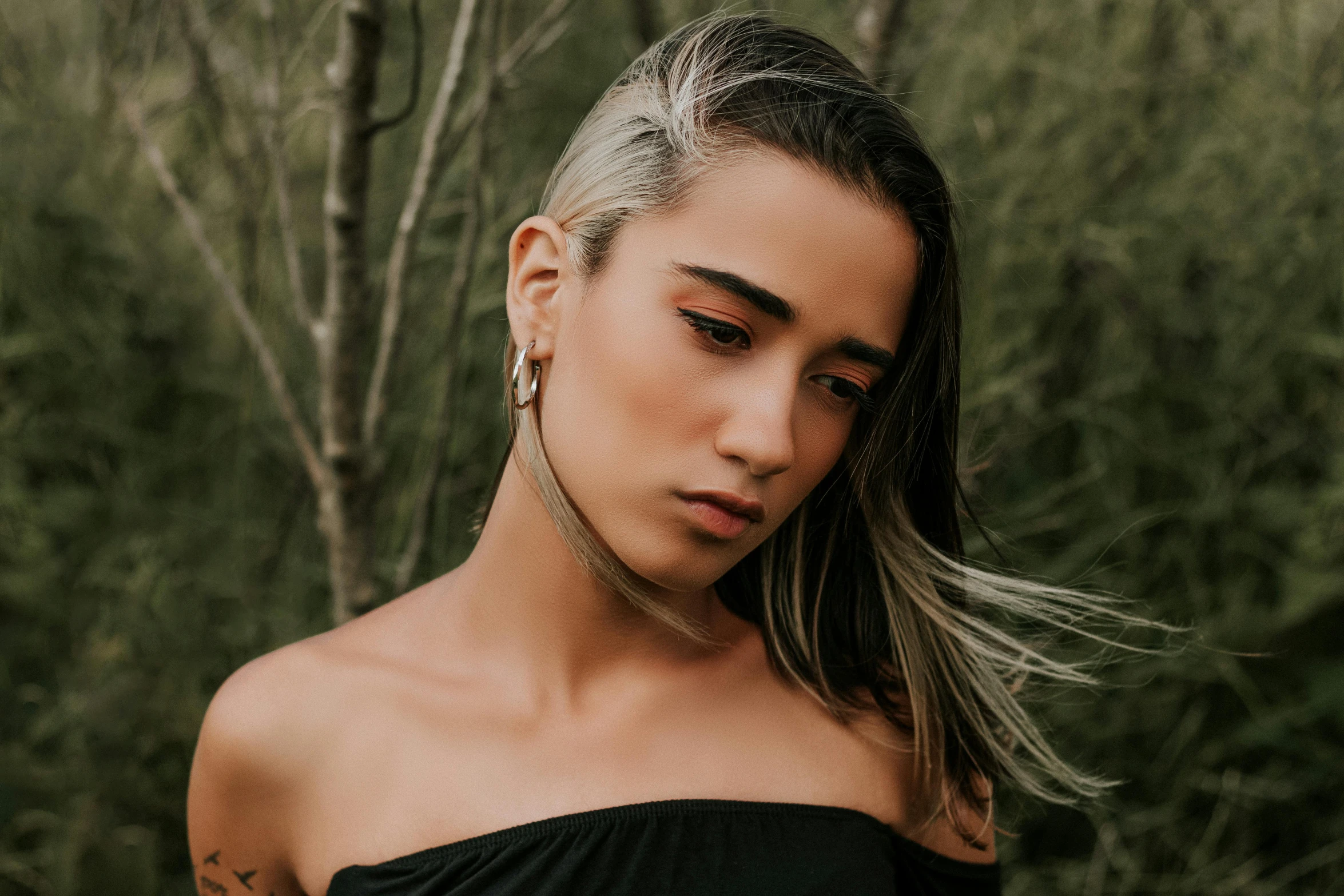 a woman in a black off the shoulder dress, inspired by Elsa Bleda, trending on pexels, hurufiyya, silver hair (ponytail), a young asian woman, earrings, resembling a mix of grimes