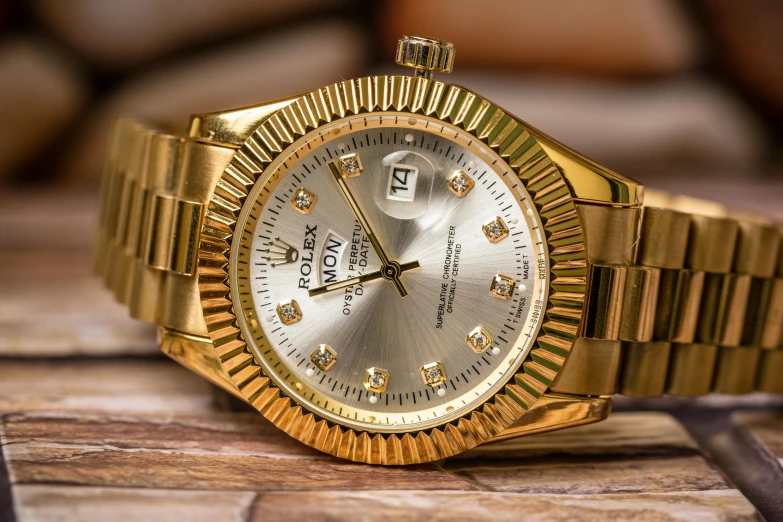 a gold watch sitting on top of a wooden table, by Jason Felix, pexels contest winner, hurufiyya, rolex, grey, spiky, thumbnail