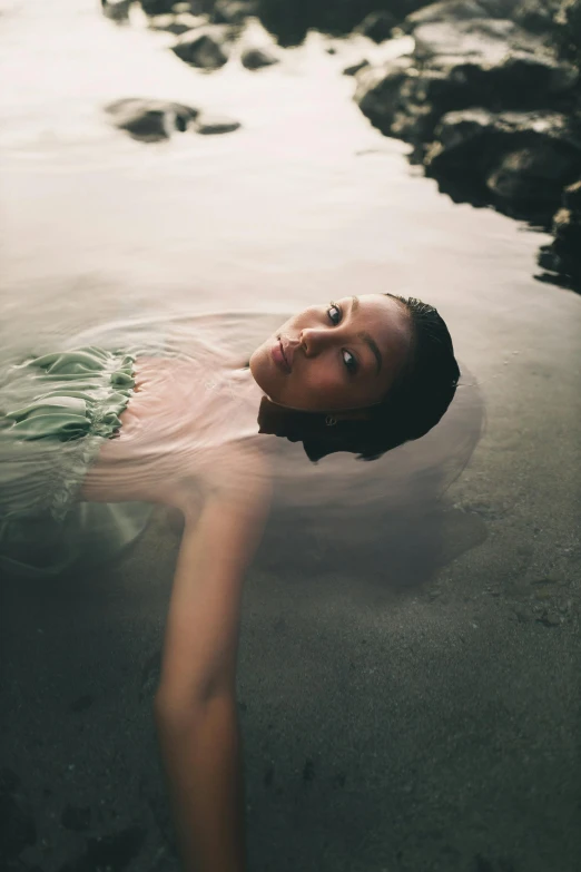 a woman swimming in a body of water, a picture, inspired by Brooke Shaden, unsplash, renaissance, black young woman, looking towards camera, green water, medium format