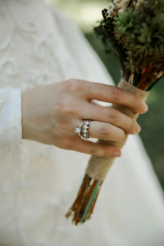 a close up of a person holding a bouquet, the ring of three wishes, creterion collection, small crown, grey