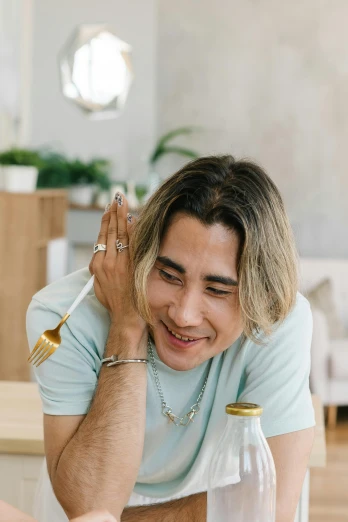 a man sitting at a table with a plate of food, an album cover, inspired by jeonseok lee, trending on pexels, avan jogia angel, earbuds jewelry, headshot profile picture, happy chef