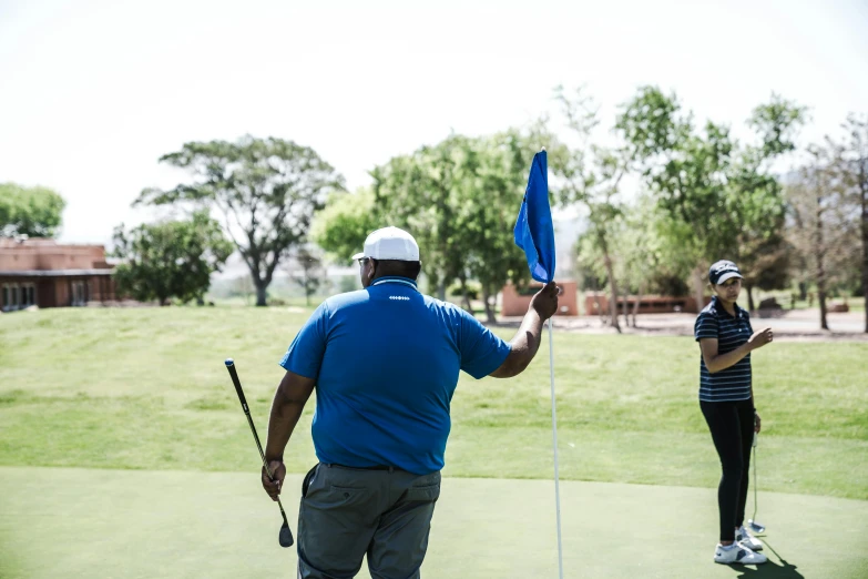 a man and a woman playing a game of golf, pexels contest winner, african ameera al taweel, holding a white flag, avatar image, outdoor photo