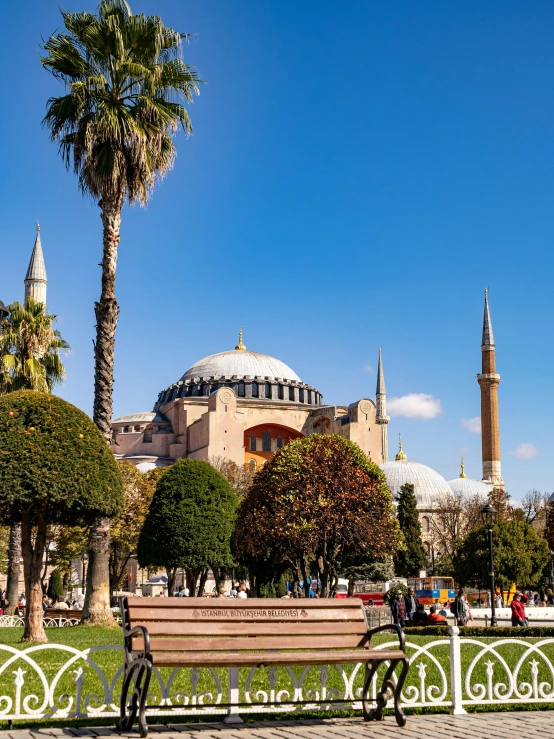 a park with benches and palm trees in front of a building, by Julia Pishtar, pexels contest winner, hurufiyya, minarets, byzantine mosaic, profile image, panorama view