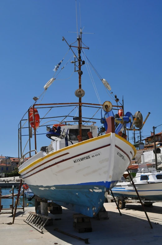 a boat sitting on top of a dock next to a body of water, mediterranean fisher village, stern like athena, on display, square