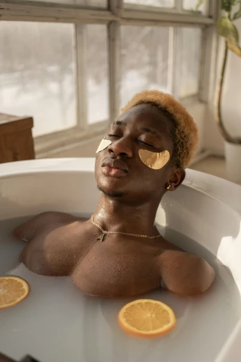 a man in a bathtub with slices of oranges on his face, trending on pexels, afrofuturism, gold bra, black teenage boy, shades, short blonde afro