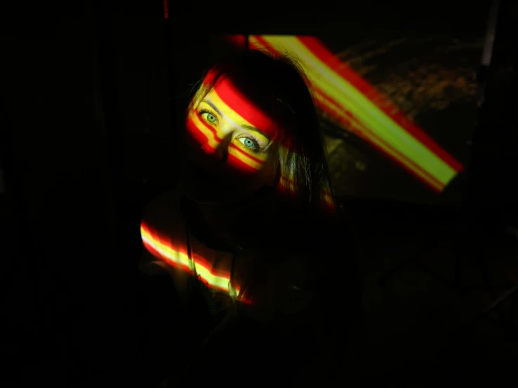 a close up of a person in a dark room, inspired by Alexander Rodchenko, unsplash, holography, red and yellow light, she is facing the camera, shadow play, laser beam ; outdoor