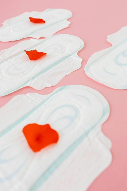 a group of disposable pads sitting on top of a pink surface, peach embellishment, poppy, in detail, flirting