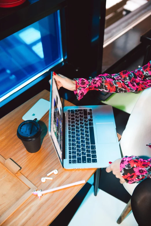 a woman sitting at a desk using a laptop computer, by Julia Pishtar, trending on unsplash, happening, top down shot, multicoloured, wearing business casual dress, high angle close up shot