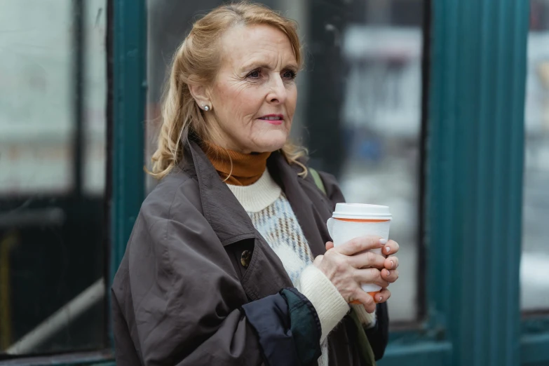 a woman is holding a cup of coffee, by Emma Andijewska, people outside walk, middle aged, looking confused, promo image