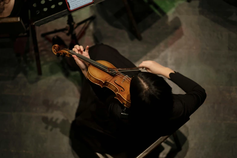 a person sitting in a chair with a violin, unsplash, avatar image, concert, wenfei ye, sheet music