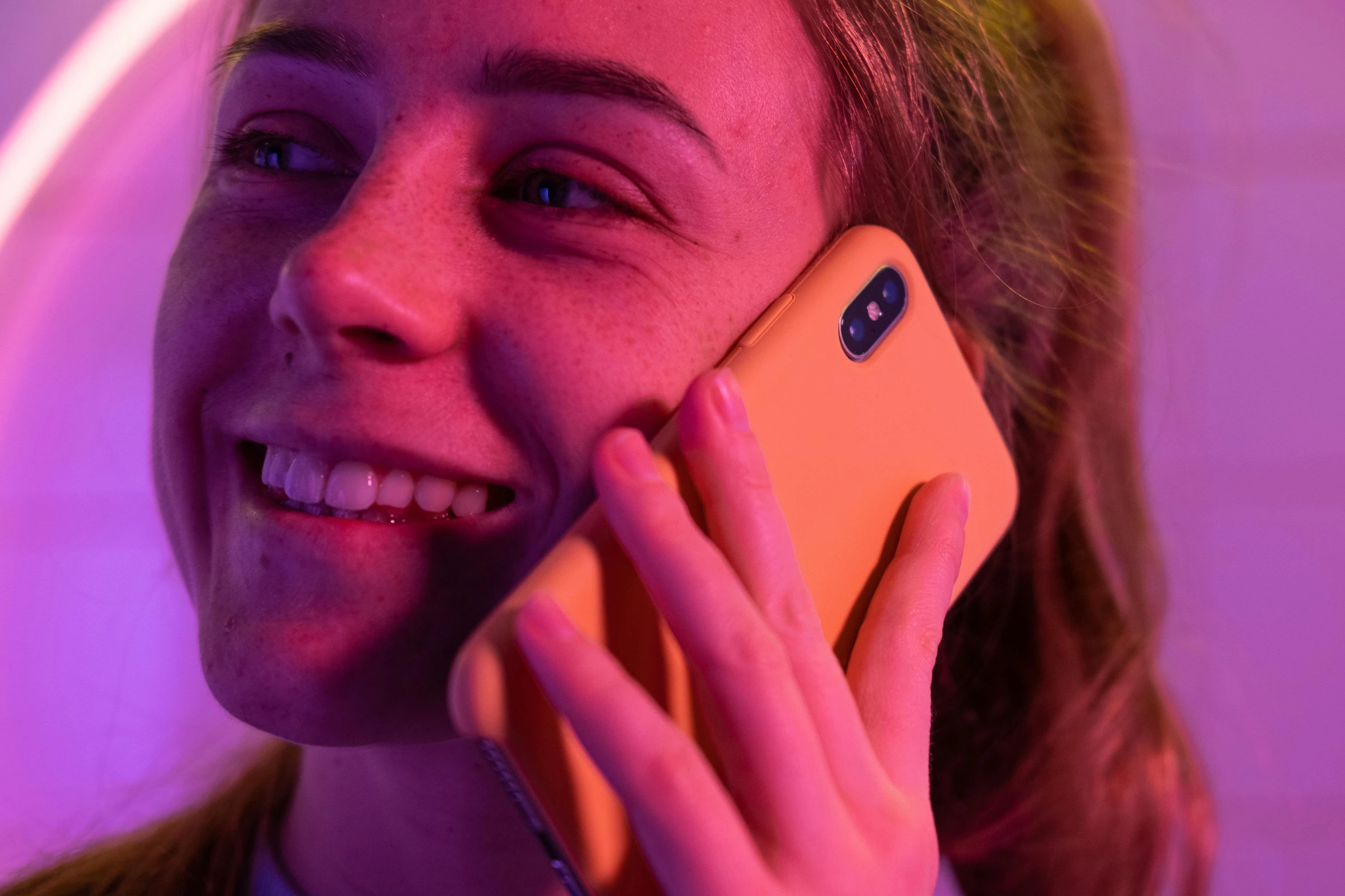 a close up of a person talking on a cell phone, some orange and purple, during the night, happy girl, press shot