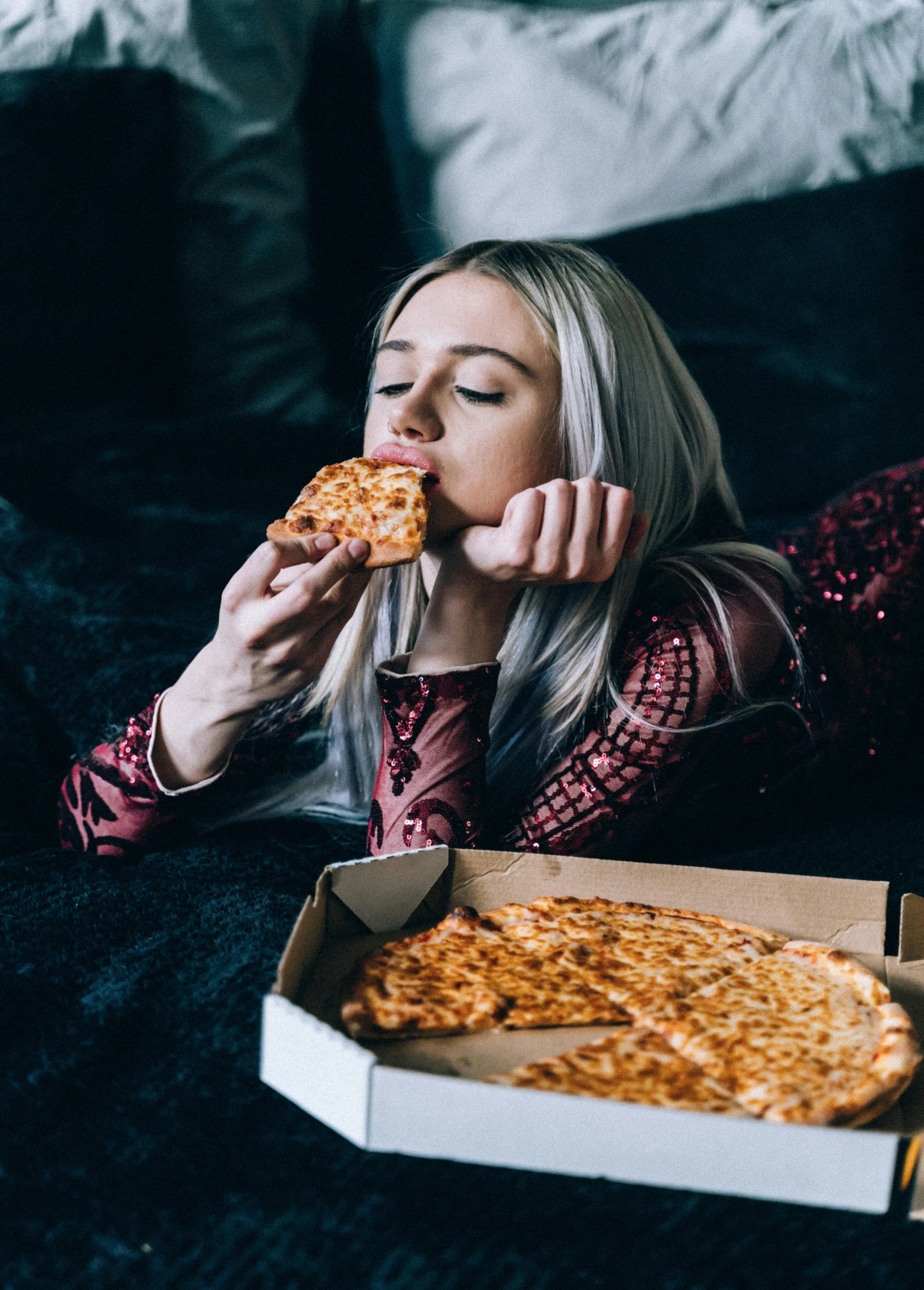 a woman laying on the floor eating a slice of pizza, inspired by Elsa Bleda, trending on unsplash, ava max, profile image, on a couch, eating cakes