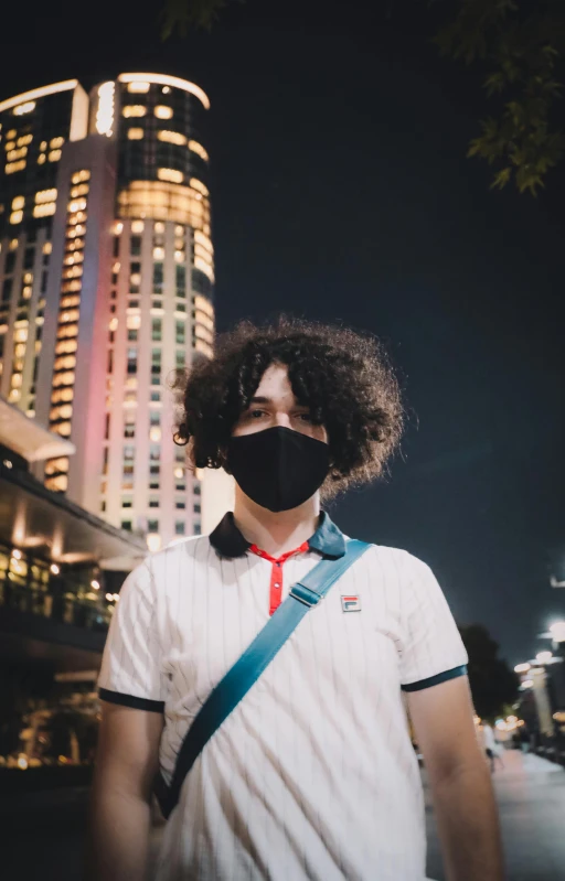 a man with curly hair wearing a face mask, an album cover, inspired by Cheng Jiasui, pexels contest winner, in tokyo at night, f / 1. 9 6. 8 1 mm iso 4 0, discord profile picture, hacker