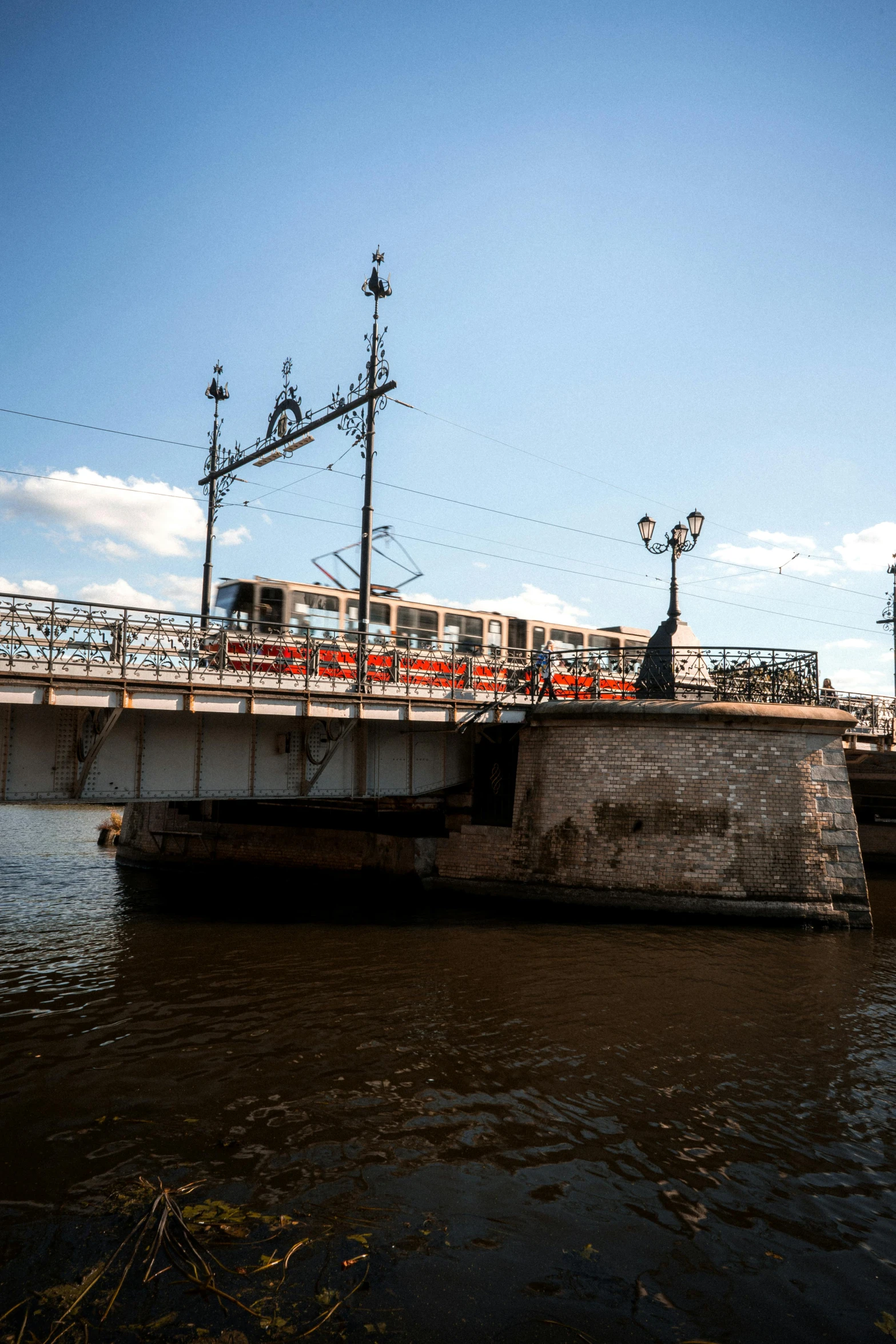 a train crossing a bridge over a river, inspired by Vasily Surikov, unsplash, art nouveau, street tram, low quality photo, exterior, fuselage