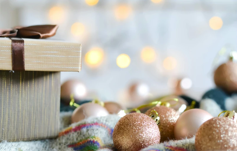 a gift box sitting on top of a pile of ornaments, by Helen Stevenson, pexels contest winner, light and space, copper details, a wooden, coloured, rectangle