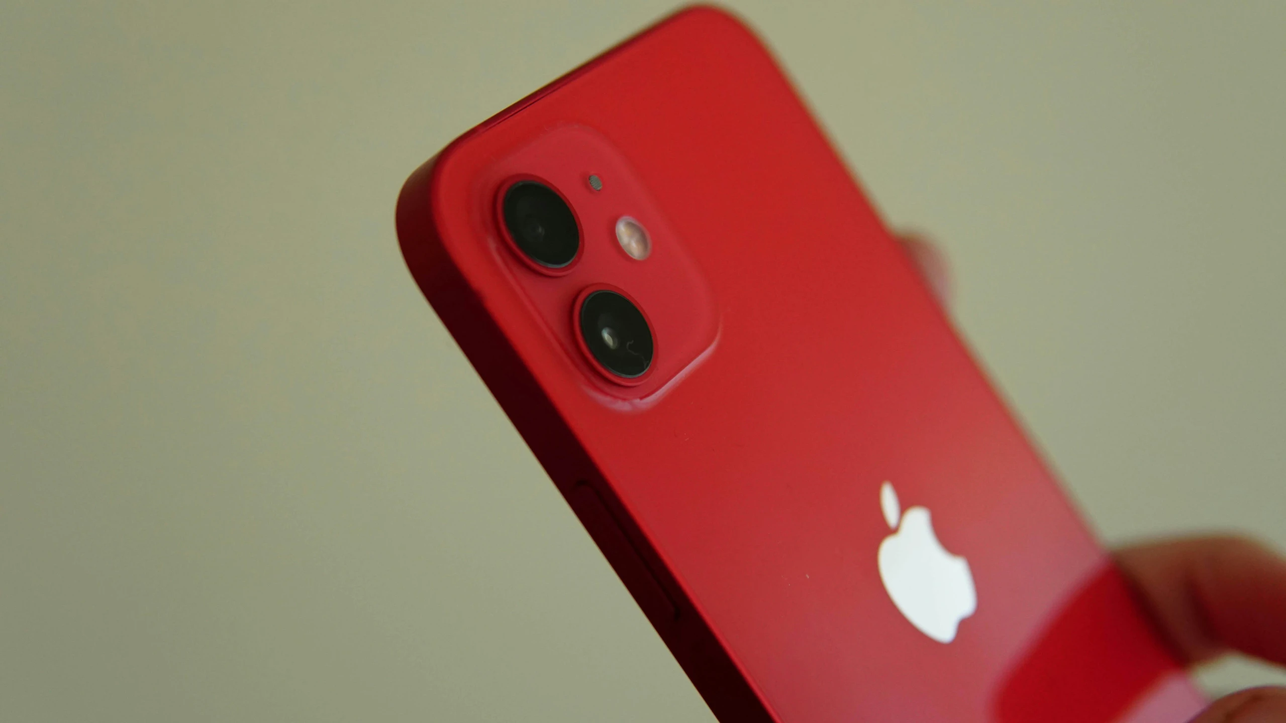 a close up of a person holding a red iphone, by Robbie Trevino, pexels, photorealism, square, iphone 12, low quality photo, a green