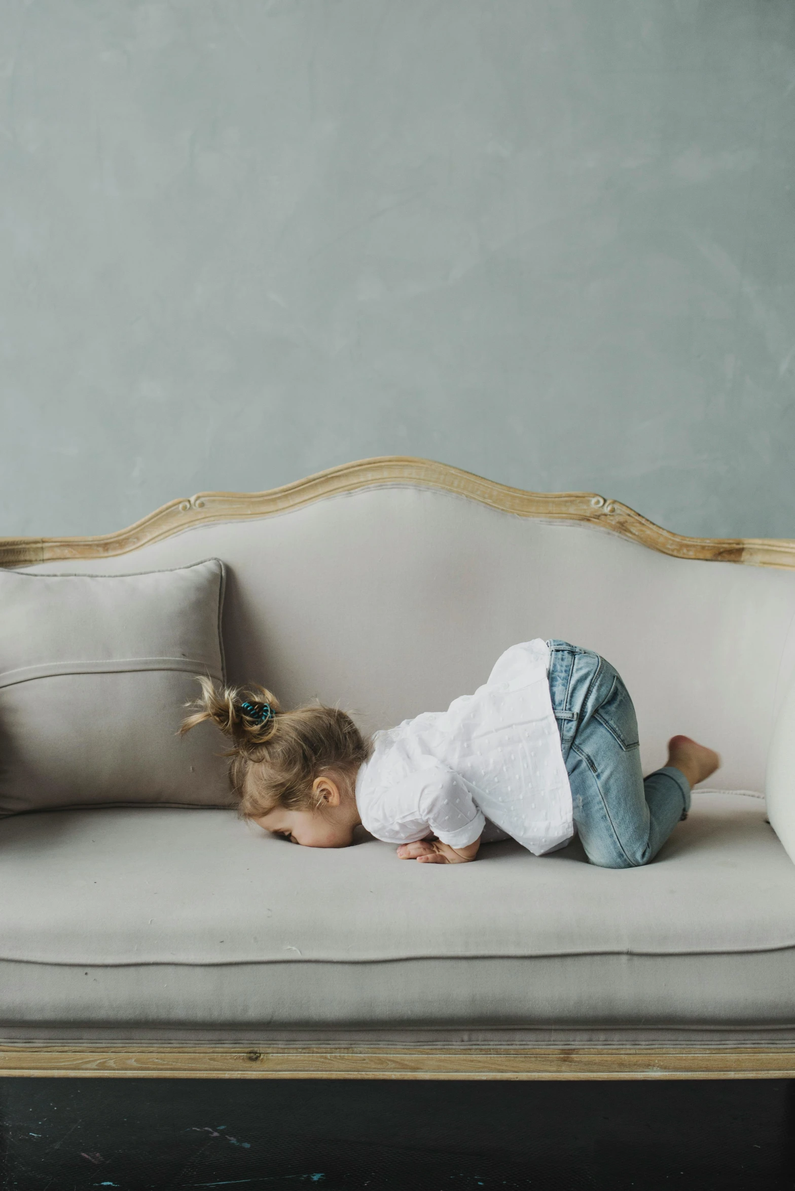 a little girl laying on top of a couch, pexels contest winner, baroque, hunched over, light grey backdrop, heartbroken, arched back