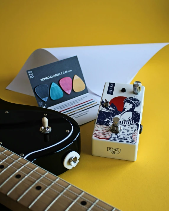 a guitar sitting on top of a yellow table, inspired by Okada Hanko, tumblr contest winner, game pack, 3 colour print, box, resin