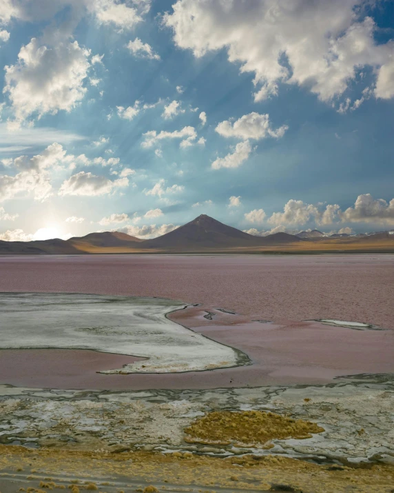 a large body of water with a mountain in the background, a colorized photo, inspired by Scarlett Hooft Graafland, pink and grey muted colors, in chuquicamata, taken in 2022, chocolate