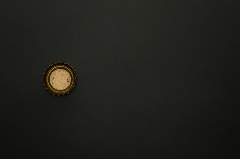 a clock sitting on top of a black wall, an album cover, by Adam Chmielowski, unsplash, conceptual art, surface with beer-texture, gold black, ffffound, black round hole