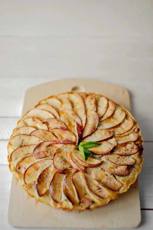 an apple pie sitting on top of a wooden cutting board, a pastel, stems, round-cropped, cascade, white
