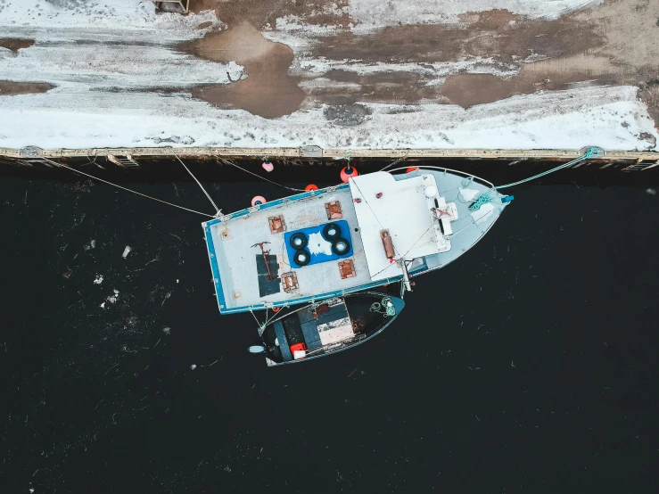 a boat sitting on top of a body of water, by Jesper Knudsen, pexels contest winner, hurufiyya, looking down from above, big graphic seiner ship, right side composition, small dock