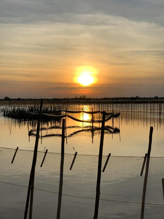 the sun is setting over a body of water, by Jan Tengnagel, pexels contest winner, land art, hoang long ly, fish in the background, farms, lagoon