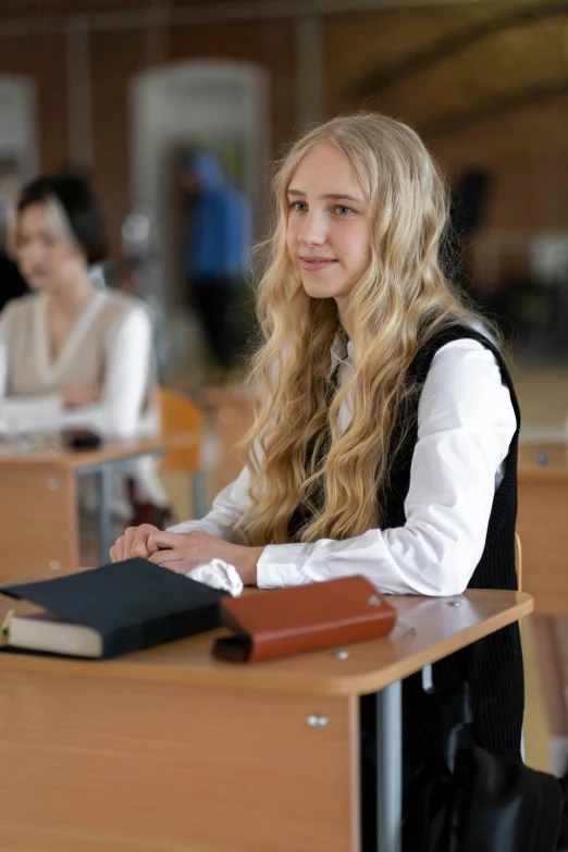 a woman sitting at a desk with a book, inspired by Anna Findlay, trending on reddit, danube school, beautiful taissa farmiga, standing in class, ( ( theatrical ) ), religion