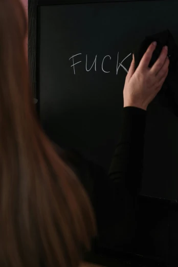 a woman writing on a blackboard with chalk, trending on reddit, promo still, filthy, full scene shot, forgiveness