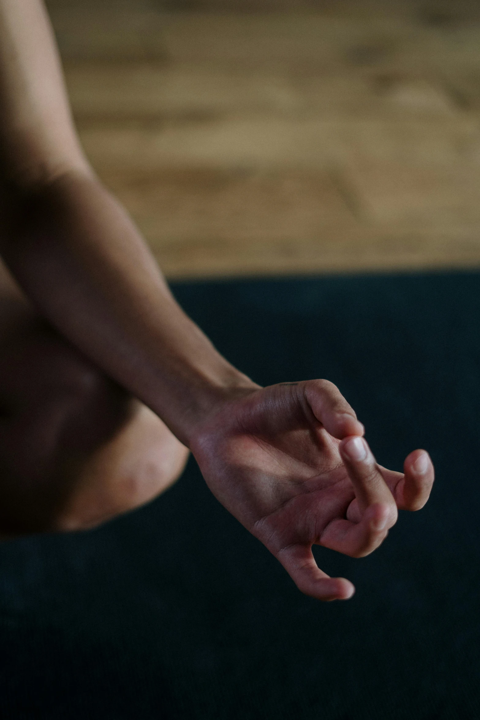 a close up of a person sitting on a yoga mat, a portrait, unsplash, hand gestures, square, no cropping, low-key