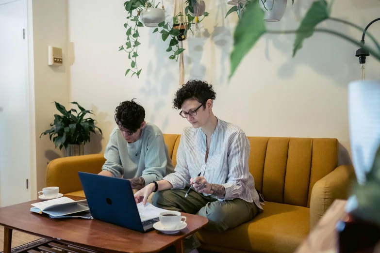 two people sitting on a couch looking at a laptop, by Jessie Algie, pexels, arbeitsrat für kunst, lawther sit at table playing dnd, lachlan bailey, sitting in a cafe, studious