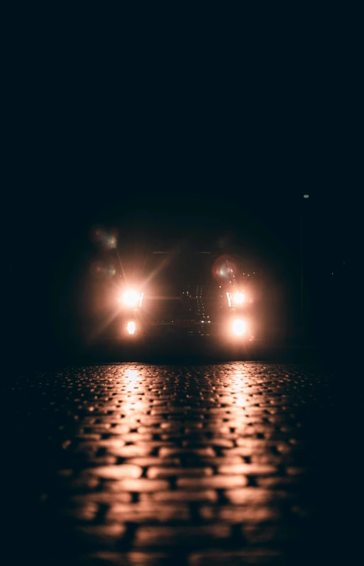 a couple of cars driving down a street at night, an album cover, by Sebastian Spreng, unsplash, wet pavement, brown, volumetric fog light, low quality photo