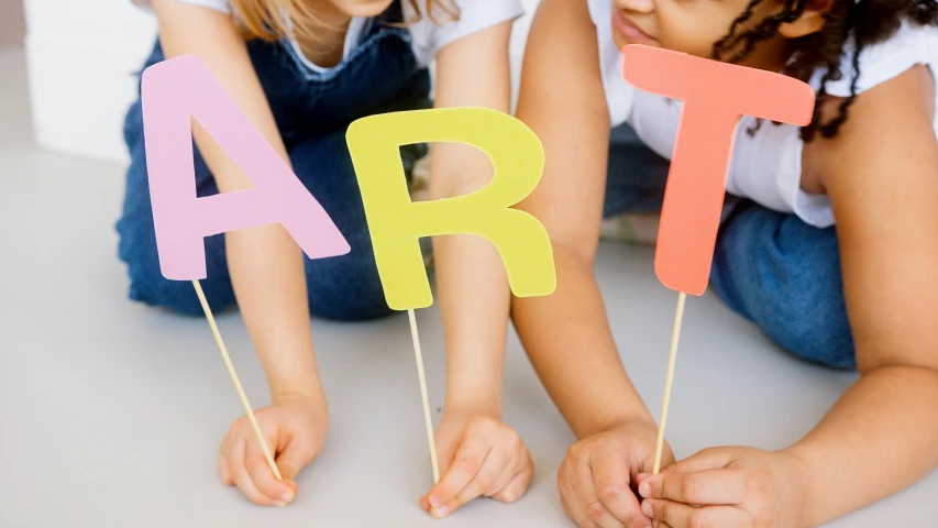 a couple of little girls sitting next to each other, a child's drawing, trending on pexels, interactive art, party balloons, letter a, promotional image