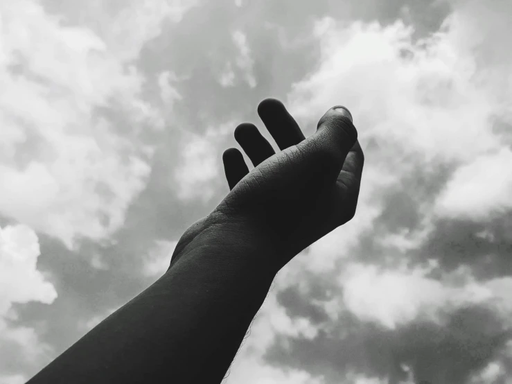 a black and white photo of a hand reaching up into the sky, instagram post, looking off to the side, holding, slightly turned to the right