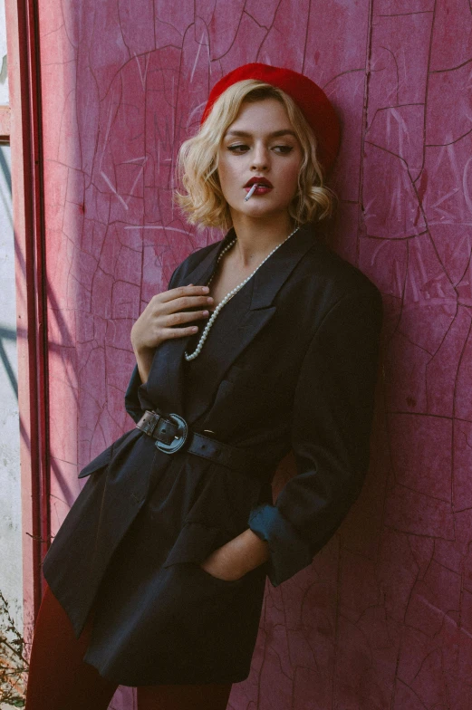 a woman in a red beret leaning against a pink wall, a portrait, inspired by Elsa Bleda, trending on pexels, wearing a black blazer, lucy hale, vintage clothing, a blond