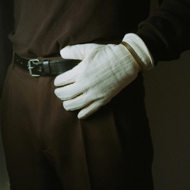 a close up of a person wearing white gloves, a colorized photo, inspired by August Sander, unsplash, renaissance, brown pants, belt, bill henson, made of fabric