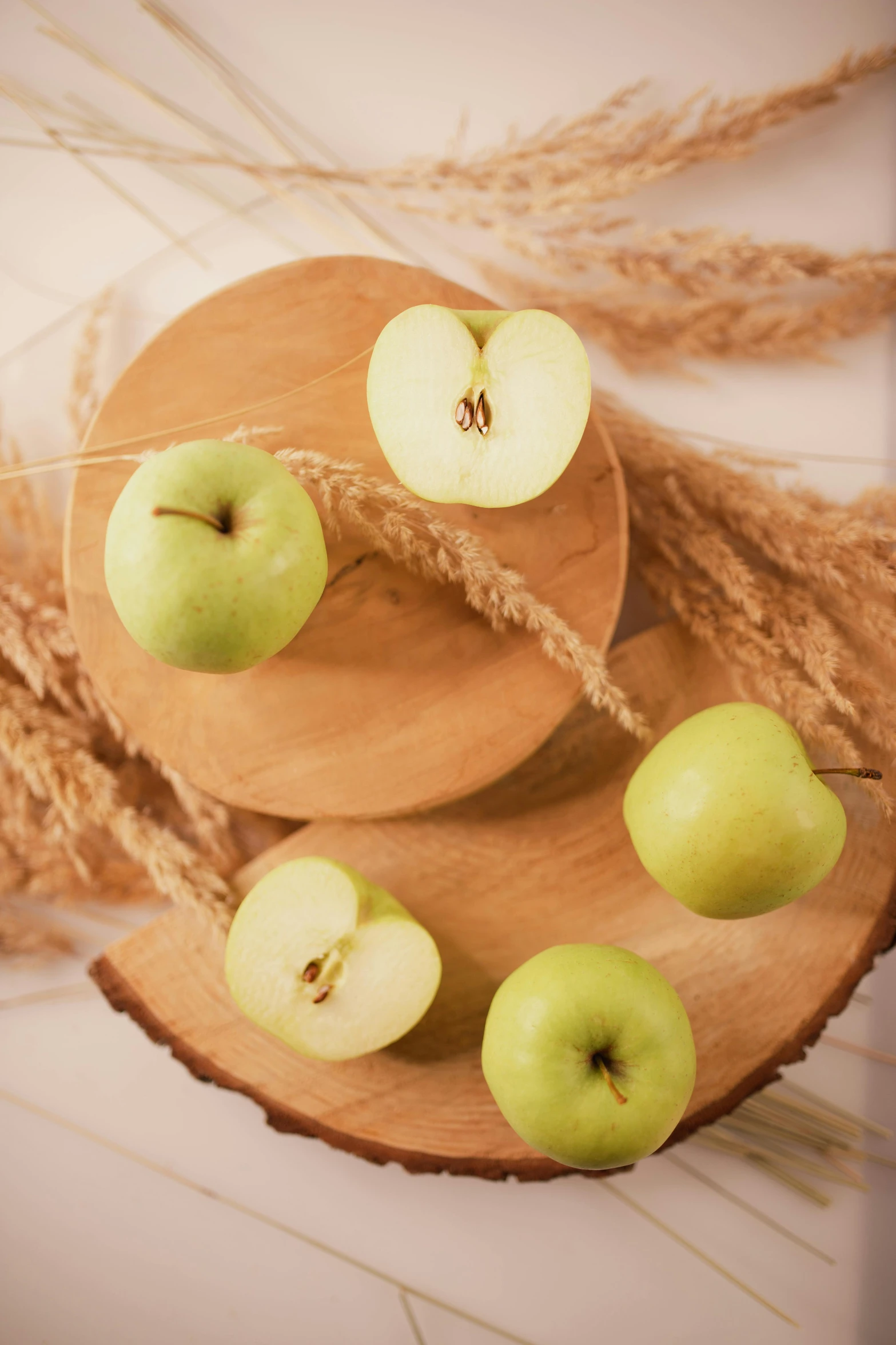 a bunch of apples sitting on top of a wooden cutting board, pale green glow, award - winning crisp details, petite, sandy green