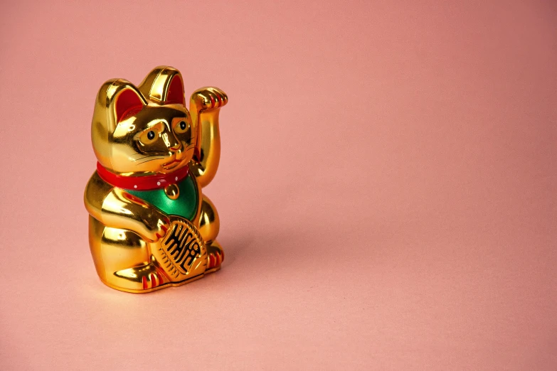 a gold figurine of a cat on a pink surface, a statue, by Julia Pishtar, pexels contest winner, cloisonnism, god of wealth, louis william wain, asian girl, foil effect